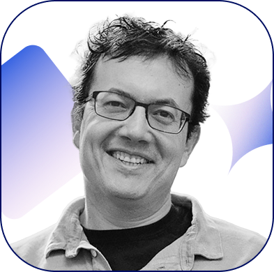 A monochrome photo of Andrew Leland, a white dude smiling.