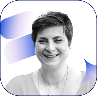 A photograph of a plus-sized fair-skinned woman with light brown hair styled in a pixie cut smiling widely.